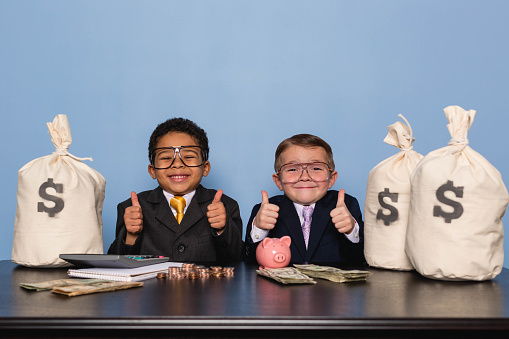 Two young business boys and entrepreneurs are loving making money and saving for the future in their company.