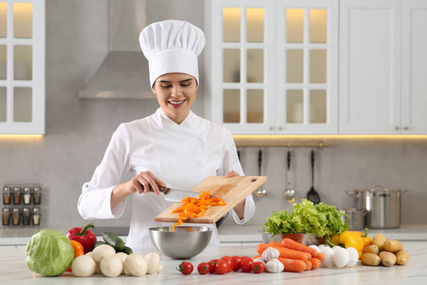 istock Professional chef putting cut bell pepper into metal bowl at white marble table in kitchen 1795478877