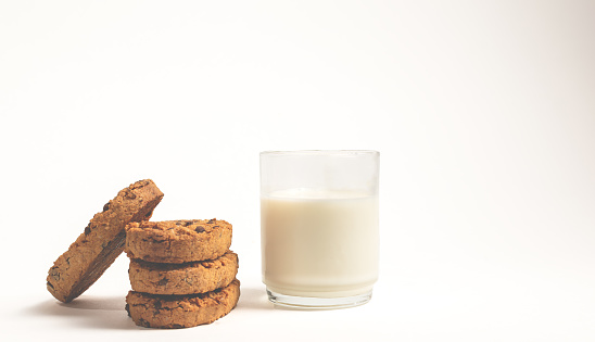 chocolate chip cookies and glass of milk on white background