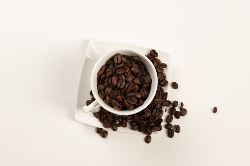 cup with coffee beans on white background