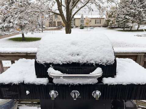 Barbecue grill covered with snow in the front yard of a house, Hopkins, Michigan, USA