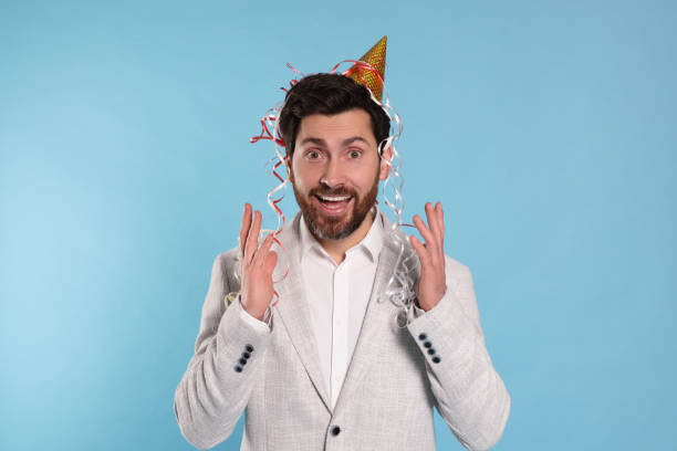 istock Emotional man with serpentine streamers on light blue background 1795529129