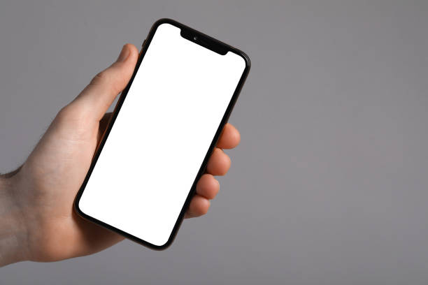 istock Man holding smartphone with blank screen on light grey background, closeup. Mockup for design 1795530207