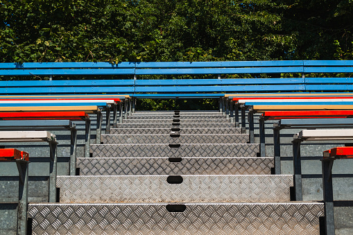 Metal stands in sports stadiums, painted in blue, red and white colors