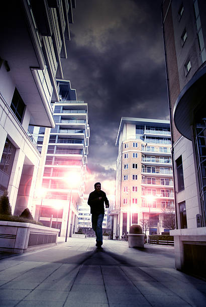 Silouette of man running through city street stock photo