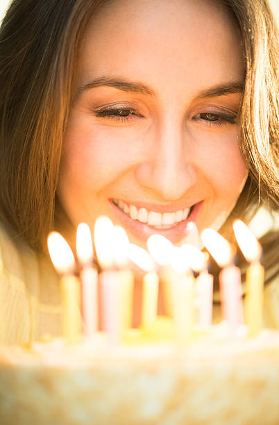istock Woman Looking At Cake With Lit Candles 179557133