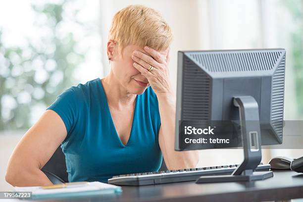 Tired Businesswoman Leaning On Computer Desk Stock Photo - Download Image Now - Mature Women, Office, One Person