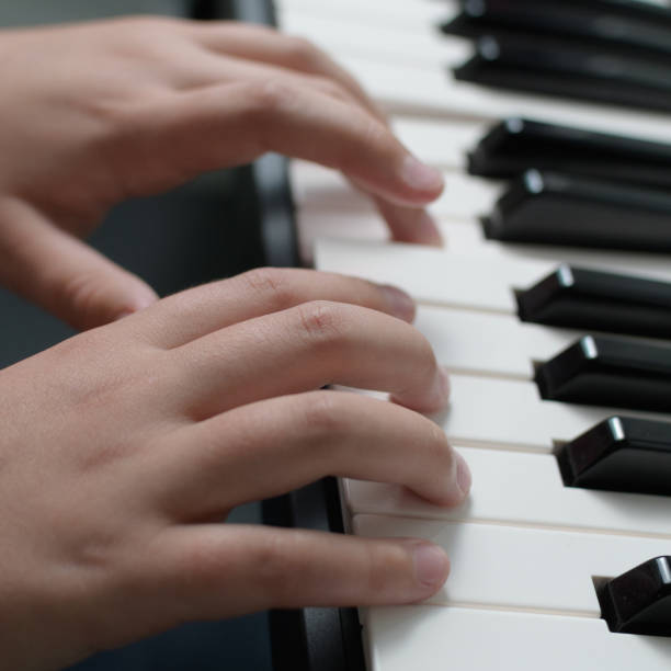 istock Piano lessons. Two hands playing exercises. Keyboard close-up 1795680414