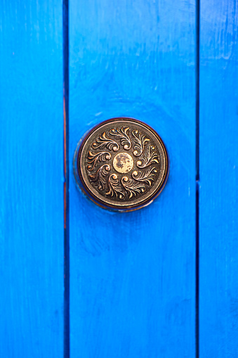 Detail of blue wooden door with round handle in Chefchaouen, Morocco, Africa.
