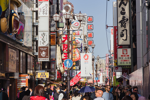 Osaka, Japan - April 13, 2023: shopping street in the Dotonbori area with unidentified people. Known as one of Osakas principal tourist and nightlife areas, the area runs along Dotonbori canal