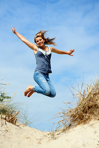 mädchen springen in den dünen - arms outstretched teenage girls jumping flying stock-fotos und bilder