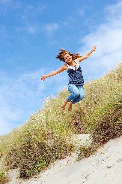 mädchen springen in den dünen - arms outstretched teenage girls jumping flying stock-fotos und bilder