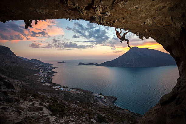 雄ロッククライマーと美しい夕暮れの眺め - climbing men sea cliff ストックフォトと画像