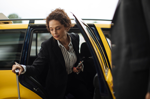 At the airport, the businesswoman's taxi ride comes to an end