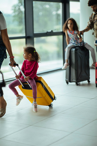 Little child takes a trip on her mother's luggage