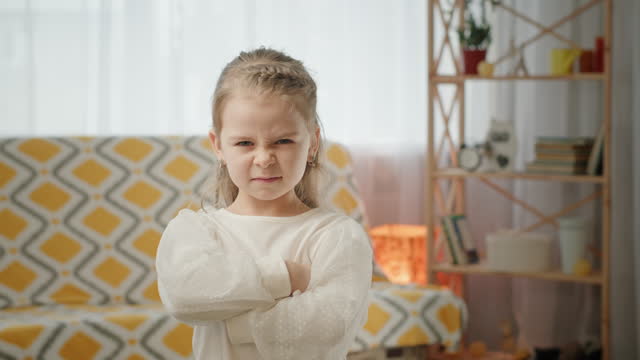 Preschooler girl holds arms crossed on chest offendedly
