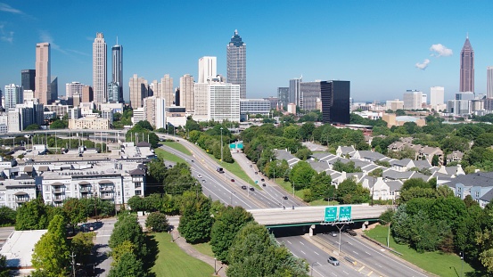 A vertical drone view of the Downtown Atlanta with modern buildings and a large green park, Georgia