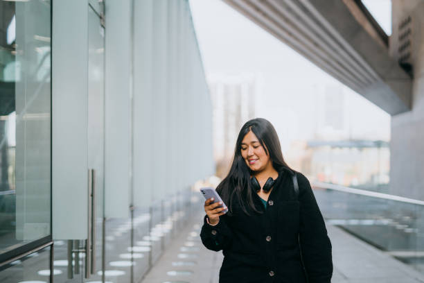 istock Woman using smartphone in financial center 1795814606