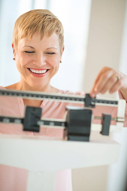 istock Cheerful Woman Using Balance Weight Scale 179584614