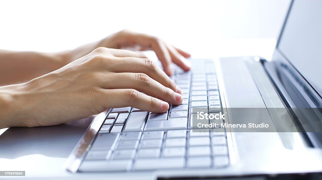 Typing on the laptop A woman working with her notebook on the table Close-up Stock Photo