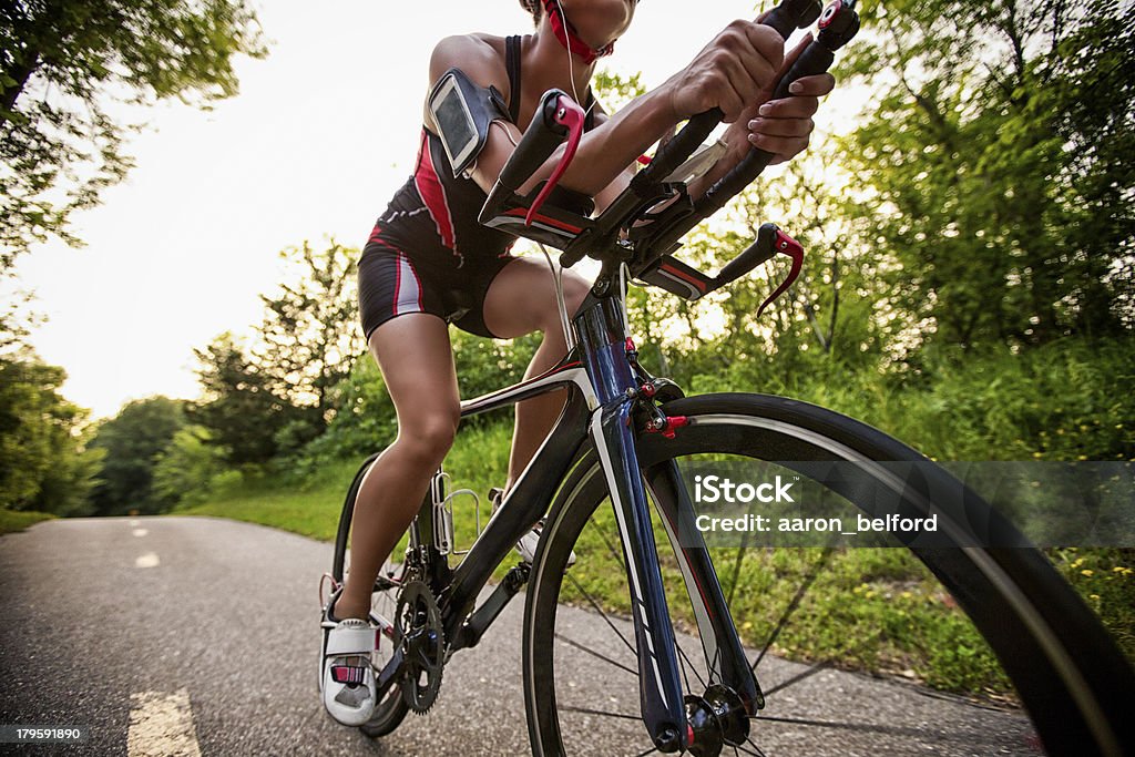 Cyclist listening music on smart phone Portrait of cyclist listening music on smart phone while riding a road bike Racing Bicycle Stock Photo