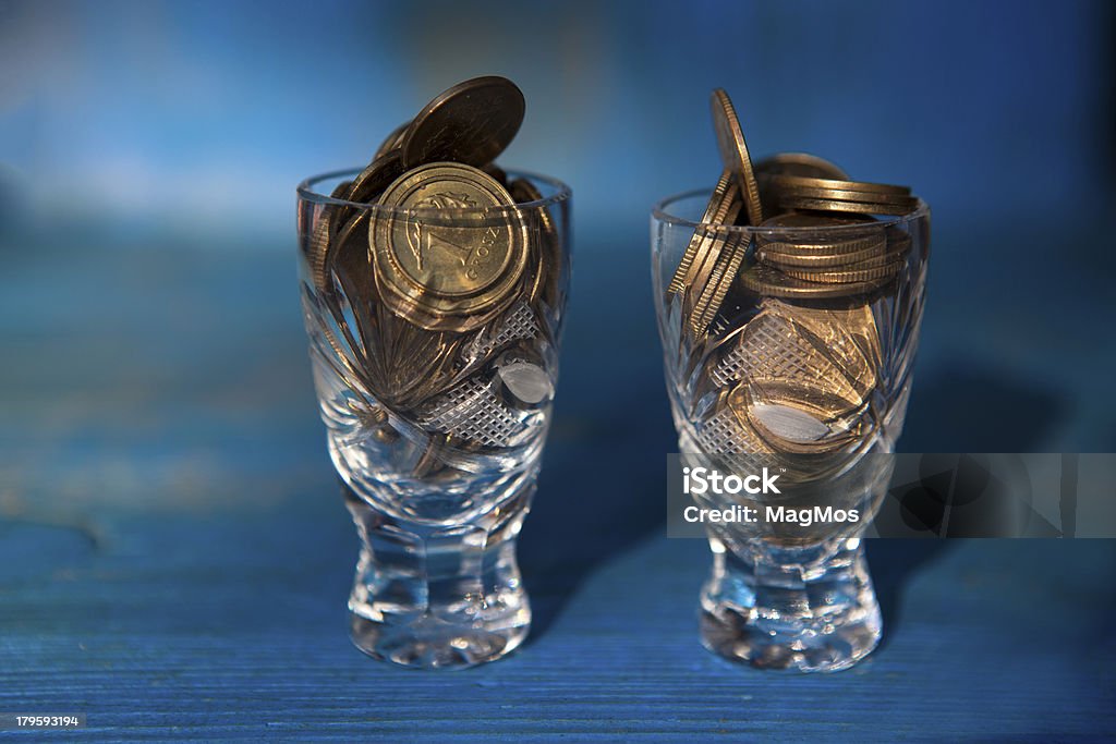 Moedas em copos de cristal-símbolo do alcoolismo. - Foto de stock de Alcoolismo royalty-free