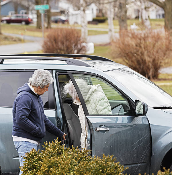 istock Caregiver Daughter Assisting Elderly Mother Into Car 179596023