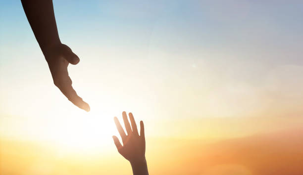 istock Hand reaching out to help someone on sunset sky background. 1795970919