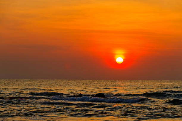 istock Sunrise on water in morning  at beach 1795971298