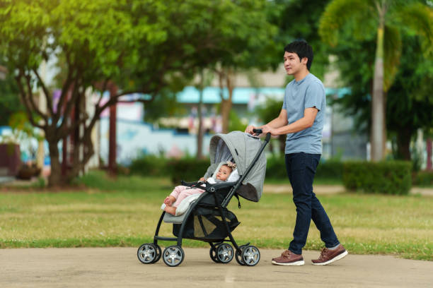 istock happy father pushing infant baby stroller and walking in park 1795995306