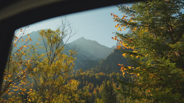 Bavarian alps visible from vehicle window during road trip in autumn