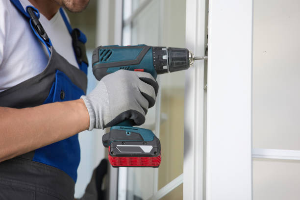 istock Experienced installer in uniform automatic screwdriver and repairs plastic door 1796018398