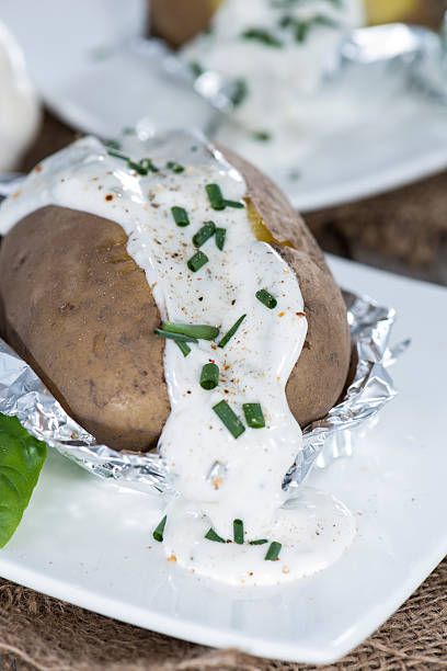 Homemade Baked Potatoe Homemade Baked Potatoe with fresh Herbs on wooden background baked potato sour cream stock pictures, royalty-free photos & images