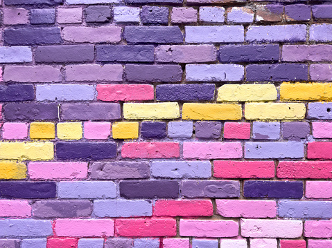 Pastel lavender color painted old brick wall wide texture. Light violet rough brickwork. Grunge panoramic background