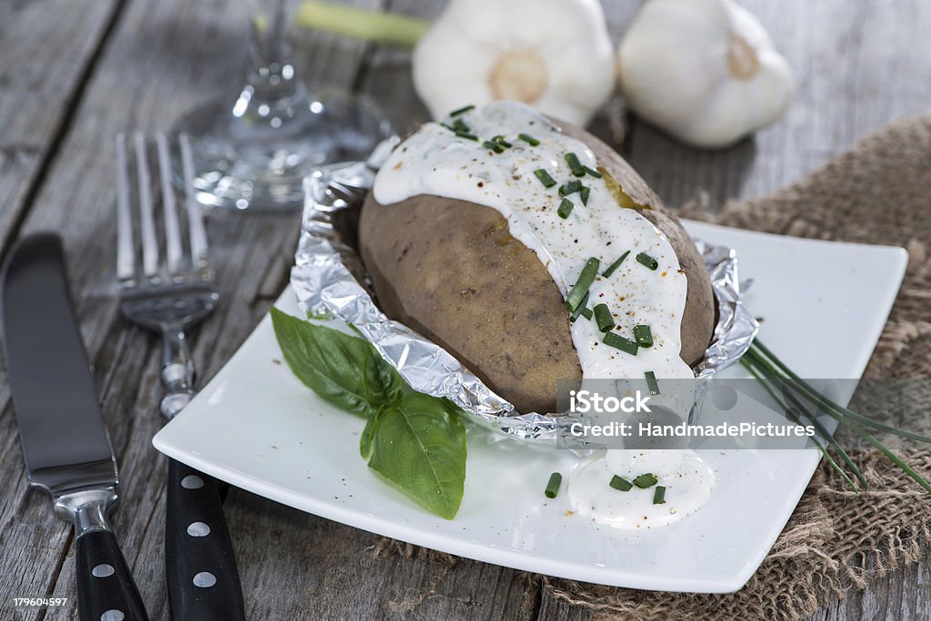 Portion of Baked Potatoe Portion of Baked Potatoe with Herbs on vintage wooden background Curd Cheese Stock Photo