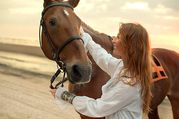 Young woman and horse on sea cost stock photo