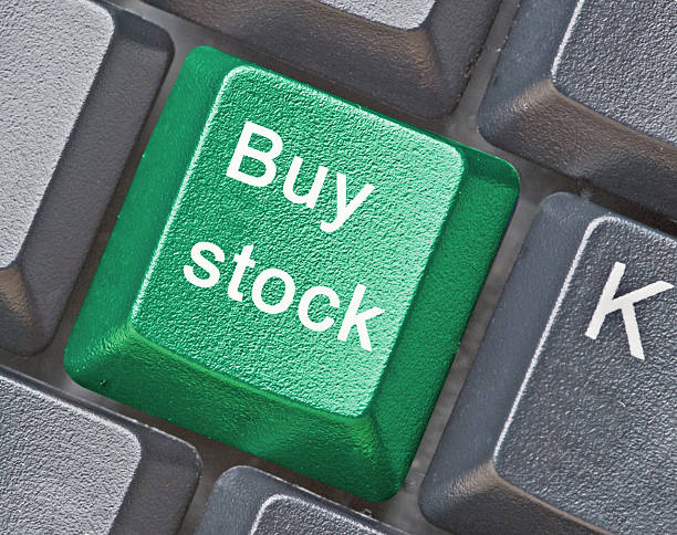 Close-up of a green buy stock button on a black keyboard stock photo