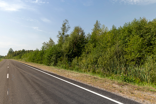 Narrow paved road for cars, part of a modern paved expressway for motor vehicles