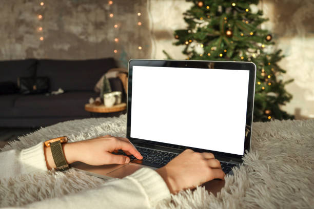 istock Young woman work on laptop computer with blank display screen with mockup copy space. Modern home living room interior design. Christmas, New Year decorated workspace 1796076625