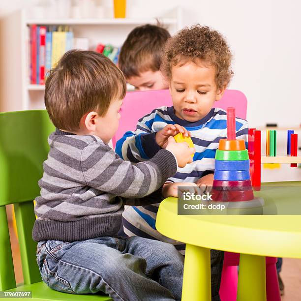 Toddlers Helping And Sharing In The Playroom Stock Photo - Download Image Now - Sharing, Child, Preschool