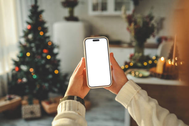 istock Phone in hands with isolated screen on Christmas kitchen background 1796077156
