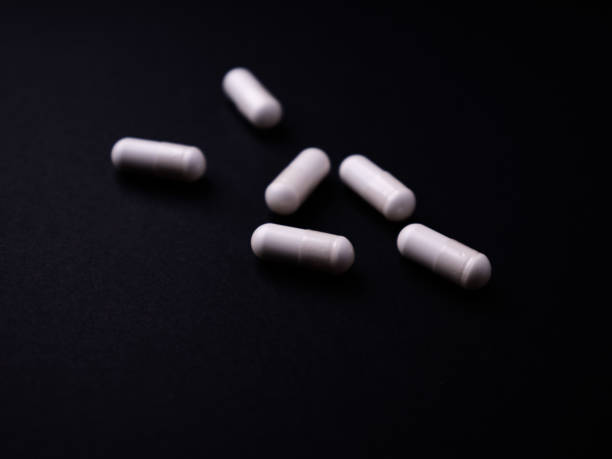 istock Creatine capsules on dark paper background. Soft focus. Close up. Copy space. 1796077215