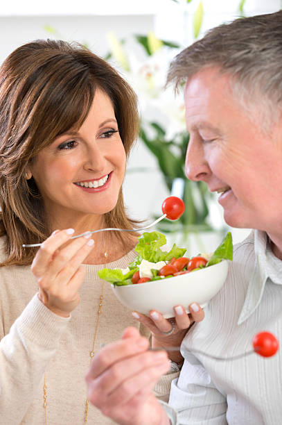 istock Mature woman feeding man salad 179614710
