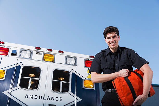 istock Paramedic standing by ambulance 179615741