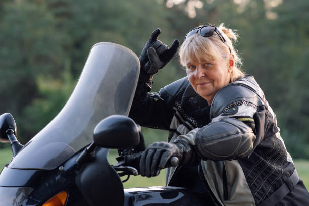 istock Super mom, blonde biker granny gestures ok while sitting on her motorcycle. Hobby motorcycle. 1796163372