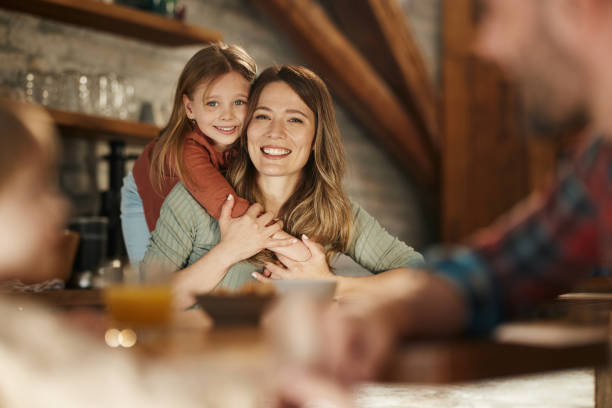 istock Happy mother and daughter embracing in dining room. 1796177601