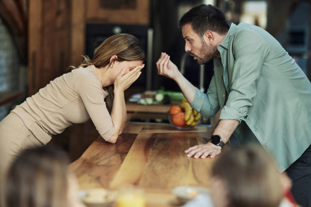 Young couple having an argument at home. Frustrated parents having an argument in the kitchen. fighting stock pictures, royalty-free photos & images
