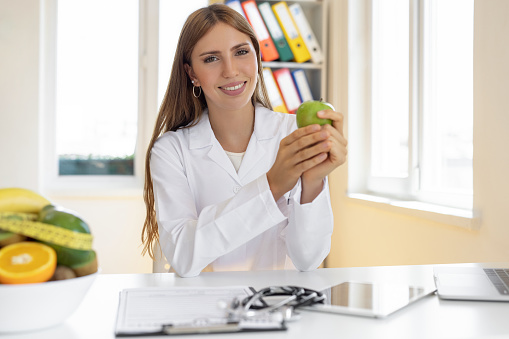Female healthy nutritionist holding an apple