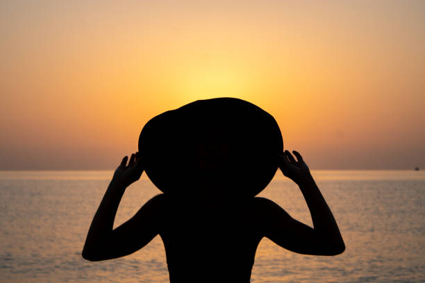 silhouette of a girl on the seashore stock photo