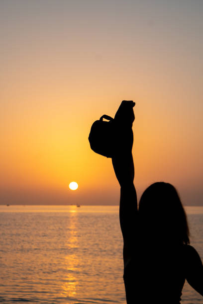 silhouette of a girl on the seashore stock photo